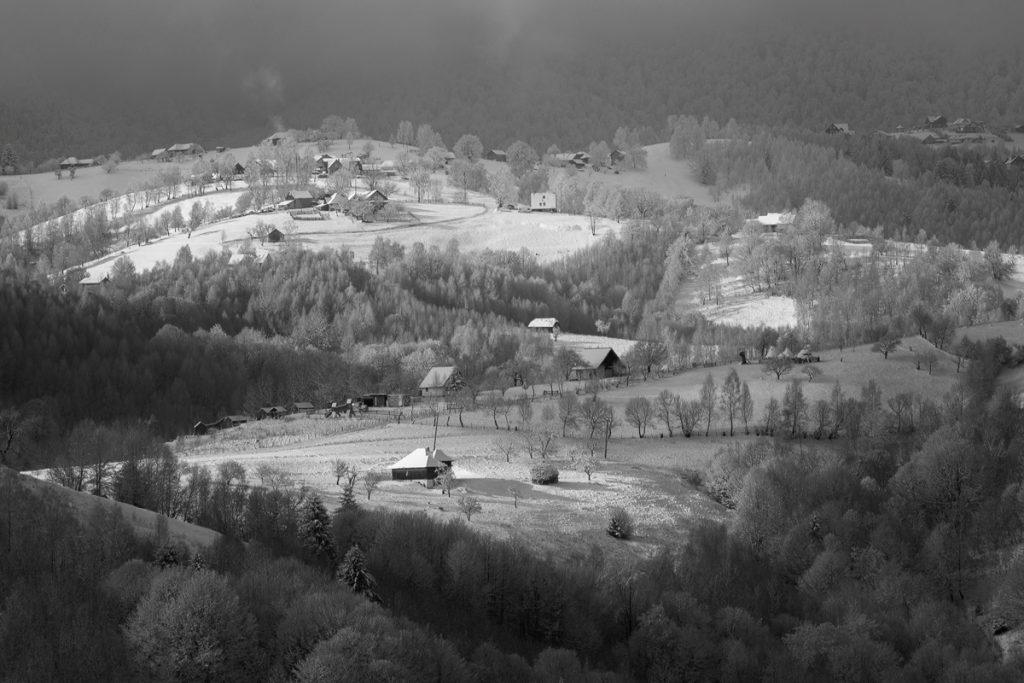 fotografie alb negru de peisaj in satul pestera iarna
